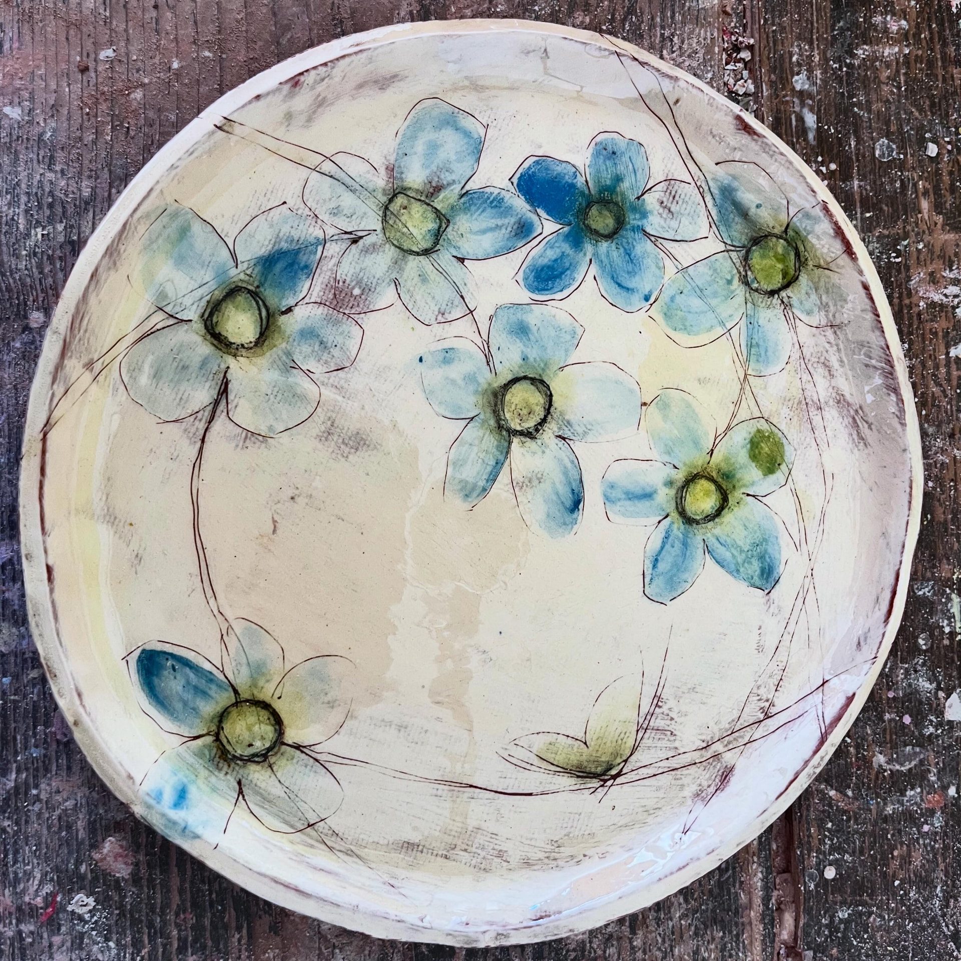 Coupe décorée de fleurs bleues sur fond crème, création de Delphine Mariotti